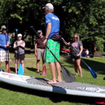Instructor demonstrating paddling a stand up paddleboard